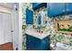 Charming bathroom with blue vanity, marble countertop, and whimsical floral wallpaper at 210 22Nd Ne Ave # 14, St Petersburg, FL 33704