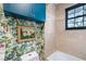 Bathroom featuring floral wallpaper, blue cabinets and shower with beige tiling at 210 22Nd Ne Ave # 14, St Petersburg, FL 33704