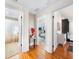 Hallway with hardwood floors connecting to a bathroom and bedroom, featuring a stylish flower arrangement at 210 22Nd Ne Ave # 14, St Petersburg, FL 33704