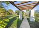 Inviting pergola frames a walkway, highlighting the lush landscaping and picturesque neighborhood in this charming community at 210 22Nd Ne Ave # 14, St Petersburg, FL 33704