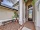 Front entry with brick pathway, wooden bench, and lush landscaping at 26848 Shoregrass Dr, Wesley Chapel, FL 33544