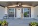 Covered front porch with a bench, potted plants, and ceiling fan at 2904 Matchlock Dr, Holiday, FL 34690