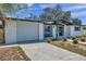 Attached garage with a white door and driveway at 2904 Matchlock Dr, Holiday, FL 34690