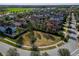 An aerial view of homes in a vibrant neighborhood with a central grassy common area at 29197 Perilli Pl, Wesley Chapel, FL 33543