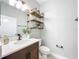 Stylish half bathroom with a modern vanity, industrial shelving, and elegant fixtures at 29197 Perilli Pl, Wesley Chapel, FL 33543