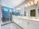 Elegant bathroom featuring dual sinks, marble countertops, and a glass-enclosed shower with tiled walls at 29197 Perilli Pl, Wesley Chapel, FL 33543