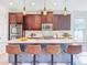 Kitchen featuring brown cabinetry, stainless steel appliances, a mosaic tile backsplash, and a large island at 29197 Perilli Pl, Wesley Chapel, FL 33543