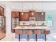 Kitchen featuring brown cabinetry, stainless steel appliances, a mosaic tile backsplash, and a large island at 29197 Perilli Pl, Wesley Chapel, FL 33543