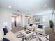 Open-concept living room with modern decor, plush seating, and abundant natural light from a large window at 29197 Perilli Pl, Wesley Chapel, FL 33543