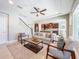 Living room view into kitchen and staircase, featuring a neutral palette and abundant natural light at 29197 Perilli Pl, Wesley Chapel, FL 33543