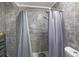 Tiled shower stall with a gray shower curtain and updated fixtures, offering a modern feel at 3087 Duane Ave, Oldsmar, FL 34677