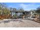 View of the home's exterior, featuring a gravel driveway and a cozy covered porch at 3087 Duane Ave, Oldsmar, FL 34677