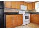 Bright kitchen features wood cabinets, granite countertops, and a white oven and microwave at 3087 Duane Ave, Oldsmar, FL 34677