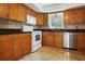 A modern kitchen with wood cabinets, black countertops, and stainless steel appliances at 3087 Duane Ave, Oldsmar, FL 34677