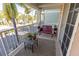 Relaxing balcony space with seating, a small table, and views of lush palm trees at 3244 Mangrove Point Dr, Ruskin, FL 33570