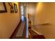 Hallway with hardwood floors transitions to carpeted stairs and elegant nautical-themed decorations at 3244 Mangrove Point Dr, Ruskin, FL 33570