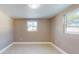 Simple bedroom with tile floors, neutral walls, and two windows for natural light at 3350 Brookfield Dr, Holiday, FL 34691