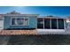 Rear exterior of home featuring blue paint, new window, and landscaped yard at 3350 Brookfield Dr, Holiday, FL 34691