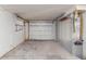 A view of the empty garage with a solid concrete floor and a white door at 3350 Brookfield Dr, Holiday, FL 34691