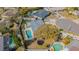 An aerial view shows this charming home features a backyard pool, trampoline, and a beautifully landscaped yard at 3704 Thornwood Pl, Tampa, FL 33618