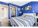 This bedroom features bold paint, striped bedding and built-in shelves at 3704 Thornwood Pl, Tampa, FL 33618