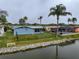 Back exterior view of house with waterfront access and a neighboring screened in pool at 3832 Star Island Dr, Holiday, FL 34691