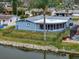 Back exterior view of waterfront home with a screened porch and tropical landscaping at 3832 Star Island Dr, Holiday, FL 34691