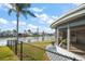 Backyard with waterfront view, enclosed lanai and tropical landscaping at 3832 Star Island Dr, Holiday, FL 34691