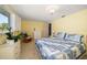 Bright bedroom with yellow walls, large window, and a blue and white patterned quilt on the bed at 3832 Star Island Dr, Holiday, FL 34691