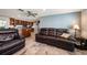 Spacious living room adjacent to an open kitchen with a large leather sofa and modern decor at 3832 Star Island Dr, Holiday, FL 34691