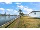 Waterfront backyard view with canal, fence, and lush green grass at 3832 Star Island Dr, Holiday, FL 34691