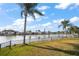 Waterfront view from backyard with tropical landscaping and calm canal at 3832 Star Island Dr, Holiday, FL 34691