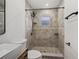 Updated bathroom with walk-in shower, modern vanity, and stone tile at 4412 W Pearl Ave, Tampa, FL 33611