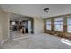 Open-concept living space with tile floors, paneled walls, and view into the kitchen awaiting renovation at 4440 Huntington Ne St, St Petersburg, FL 33703