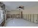 Large living space featuring tile floors, a ceiling fan, and paneled walls awaiting renovation at 4440 Huntington Ne St, St Petersburg, FL 33703