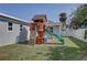 Backyard with a wooden playset, including a slide and climbing wall, perfect for Gathering fun at 4440 Huntington Ne St, St Petersburg, FL 33703