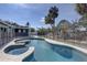 Beautiful backyard pool featuring a hot tub and black safety fence, surrounded by lush tropical landscaping at 4440 Huntington Ne St, St Petersburg, FL 33703