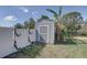 Backyard storage shed with white fencing and lush vegetation, providing practical outdoor storage at 4440 Huntington Ne St, St Petersburg, FL 33703