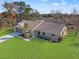 An aerial view of a home that shows its mature landscaping, a sprawling lawn, and a cozy front porch at 4472 Bayridge Ct, Spring Hill, FL 34606