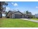 Inviting front exterior with a two car garage, lush lawn, and a cozy covered porch at 4472 Bayridge Ct, Spring Hill, FL 34606