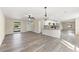 Open-concept living area flows to kitchen, featuring a ceiling fan and wood-look flooring at 4472 Bayridge Ct, Spring Hill, FL 34606