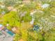 Aerial shot of property with mature trees, nearby pool, shed, and neighborhood at 4636 W Longfellow Ave, Tampa, FL 33629