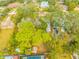 Aerial view of lush property featuring a pool, shed, mature trees, and surrounding neighborhood at 4636 W Longfellow Ave, Tampa, FL 33629