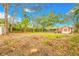 Expansive backyard featuring mature trees, shed, lush greenery, and exterior of home at 4636 W Longfellow Ave, Tampa, FL 33629