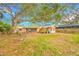 Back of a cozy house with a screened porch overlooking a lush, green backyard at 4636 W Longfellow Ave, Tampa, FL 33629