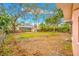 Spacious backyard featuring a mix of trees, grass, and a shed along a wooden fence at 4636 W Longfellow Ave, Tampa, FL 33629