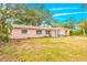 Inviting pink single-story home with white framed windows and covered entry at 4636 W Longfellow Ave, Tampa, FL 33629