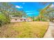 Inviting pink single-story home with white framed windows, landscaping and a private driveway at 4636 W Longfellow Ave, Tampa, FL 33629