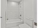 Clean bathroom with a white bathtub, toilet, and marble-style tile at 5120 Marina Way # 14002, Tampa, FL 33611