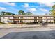 Condo building exterior showing the carports, second story, neutral paint, and manicured landscaping at 5265 E Bay Dr # 424, Clearwater, FL 33764